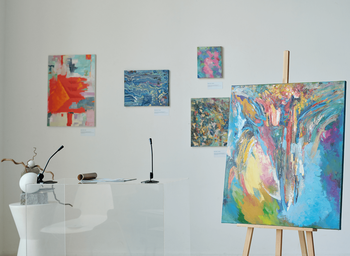 Art gallery with colorful abstract paintings displayed.